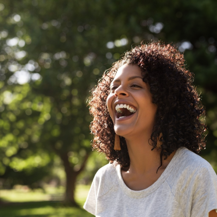 healthy laughing woman enjoying life outside in the sun